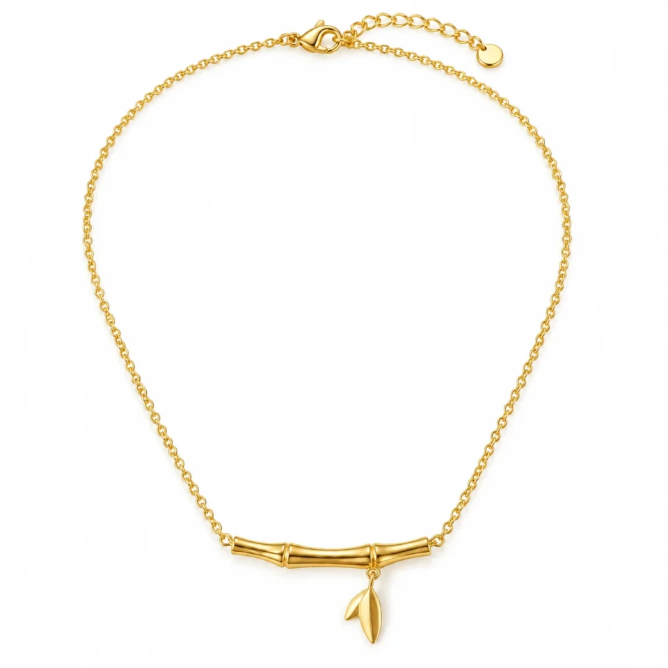 18K gold plated bamboo bar pendant necklace with a small dangling leaf charm on a fine cable chain, on a white background