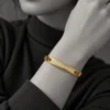 18K gold plated hinged bangle with a row of ten clear crystals and cut-out window details
