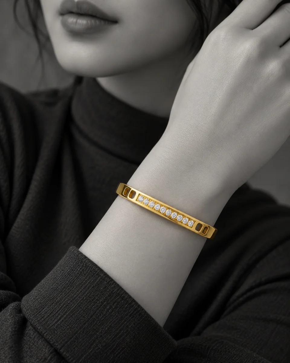 18K gold plated hinged bangle with a row of ten clear crystals and cut-out window details
