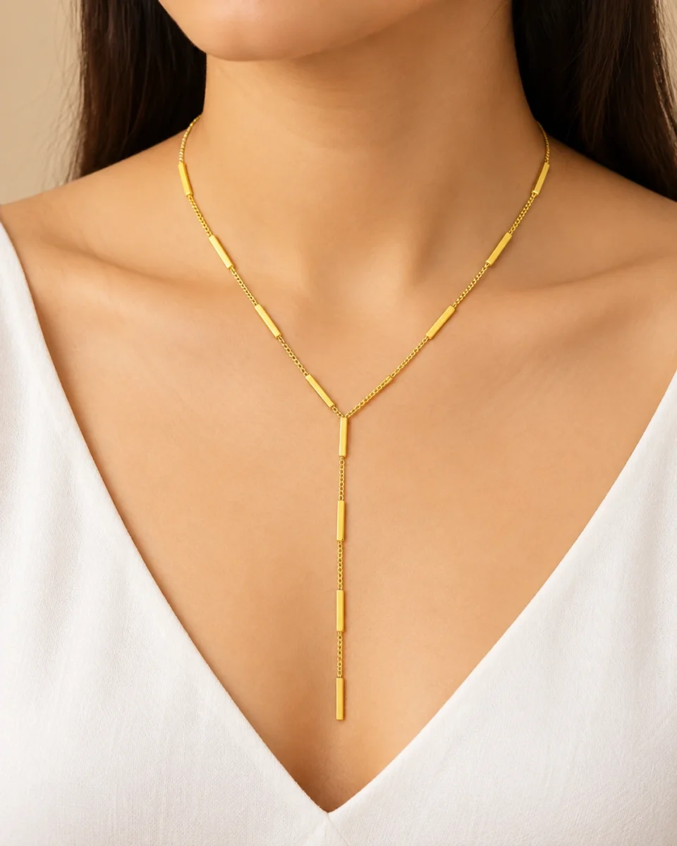 18K gold plated Y-shaped lariat necklace with polished bar stations on a fine curb chain and a three-bar drop, on a white background