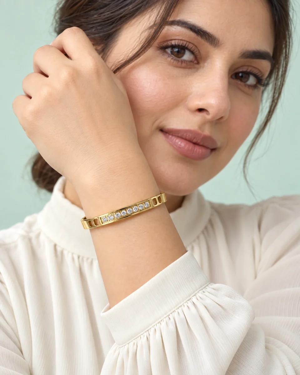 18K gold plated hinged bangle with a row of ten clear crystals and cut-out window details
