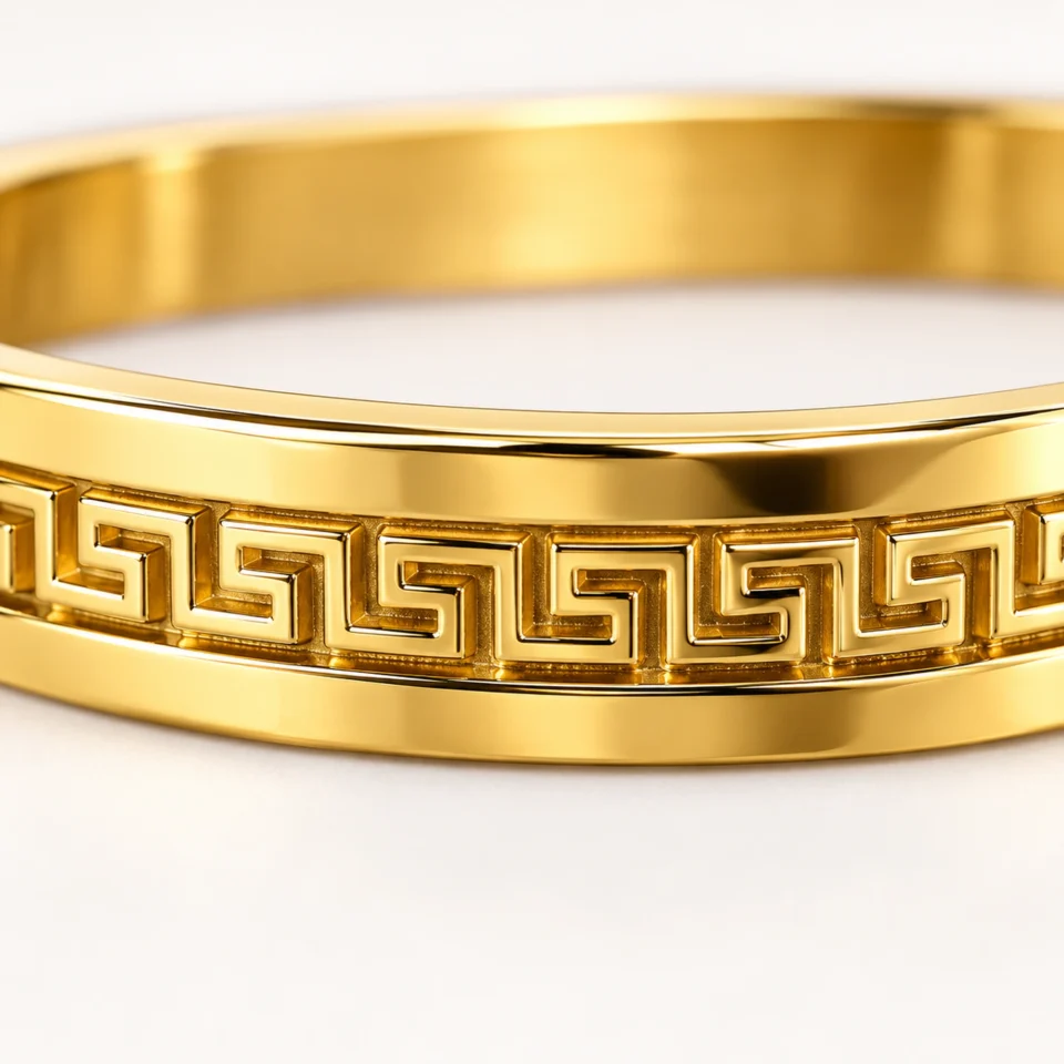 18K gold plated hinged bangle with a raised Greek key pattern around the band closeup