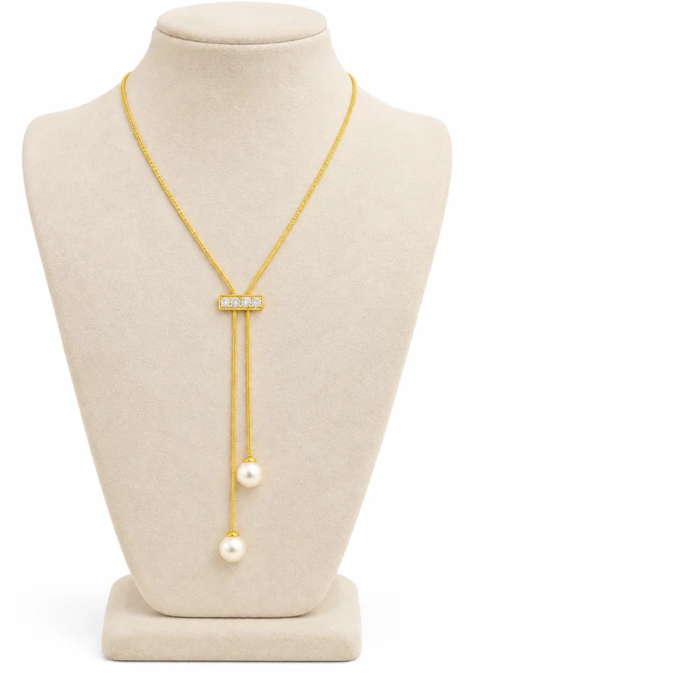 18K gold plated adjustable lariat necklace with a crystal bar slider and two pearl drops on a white background