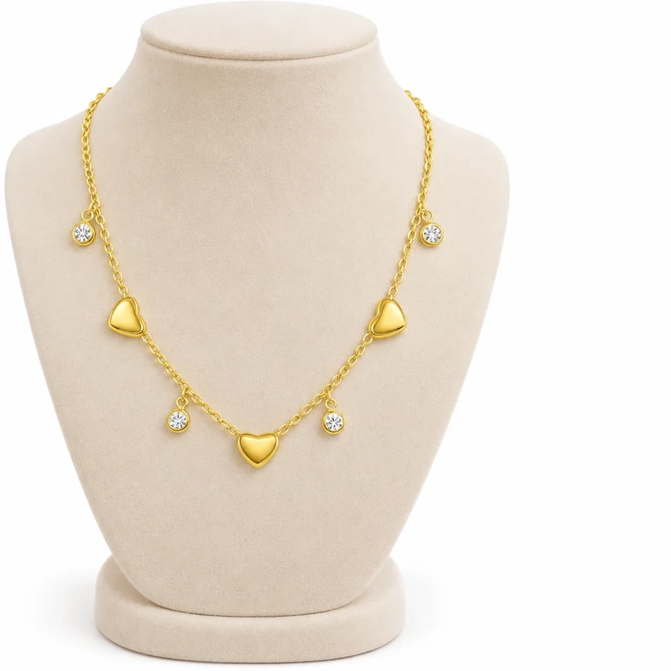 18K gold plated chain bracelet with three puffy heart charms and four bezel-set crystal drops, with lobster clasp and extender, on a white background