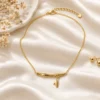 18K gold plated bamboo bar pendant necklace with a small dangling leaf charm on a fine cable chain, on a white background