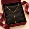 18K gold plated Y-shaped lariat necklace with polished bar stations on a fine curb chain and a three-bar drop, on a white background