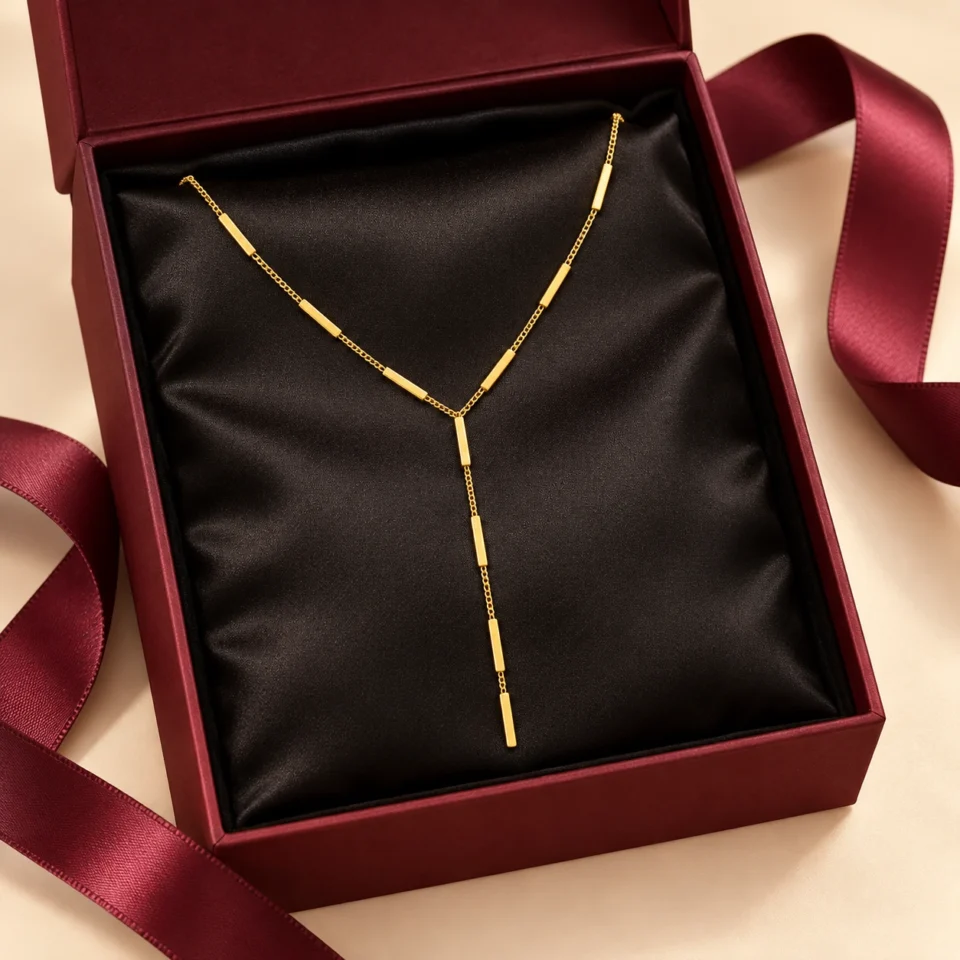 18K gold plated Y-shaped lariat necklace with polished bar stations on a fine curb chain and a three-bar drop, on a white background