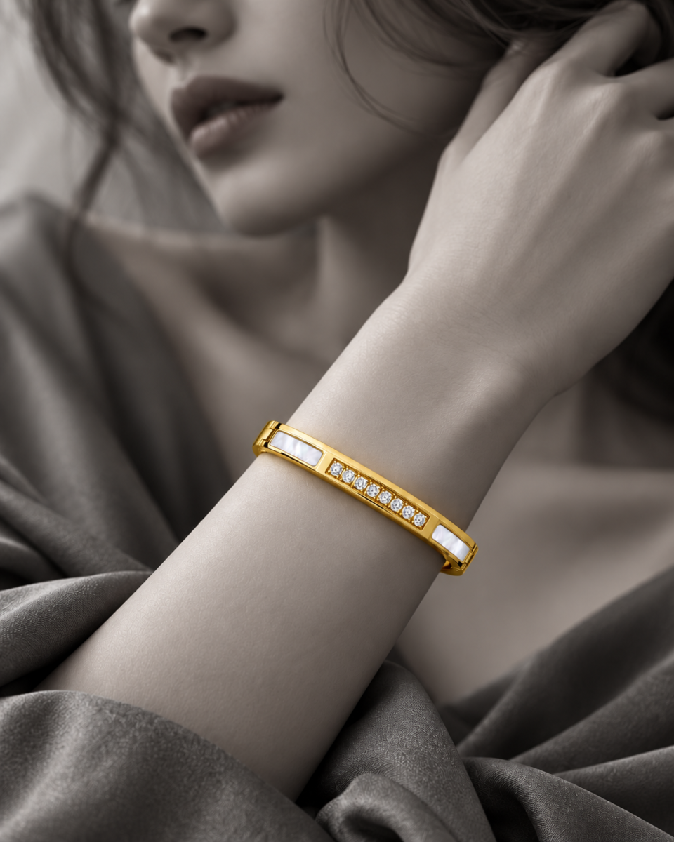 18K gold plated hinged bangle bracelet with a row of clear crystals and mother-of-pearl inlays on professional model
