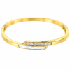18K gold plated hinged crossover bangle with a bar of clear crystals overlapping a mother-of-pearl inlay on a white background